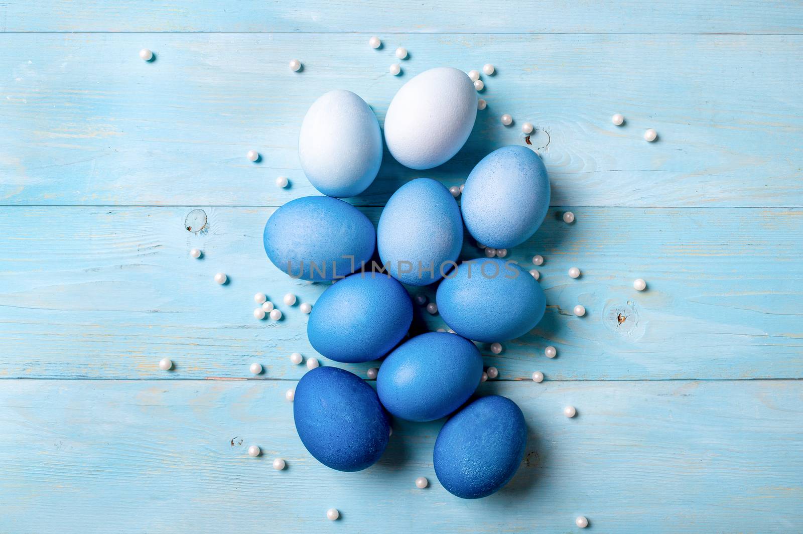 Easter concept. Ombre eggs in blue colors on blue wooden background with copy space for text. Top down view or flat lay. Classic blue colors in Easter 2020