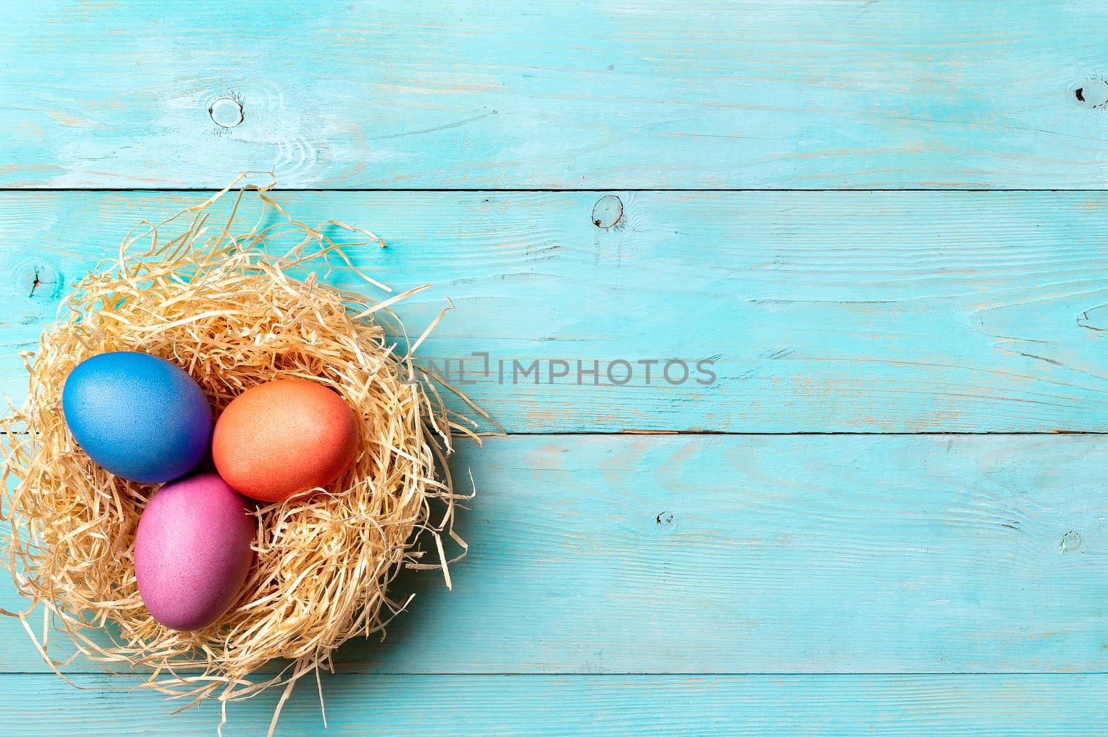 Easter concept. Colorful eggs on blue wooden background with copy space for text. Top down view or flat lay