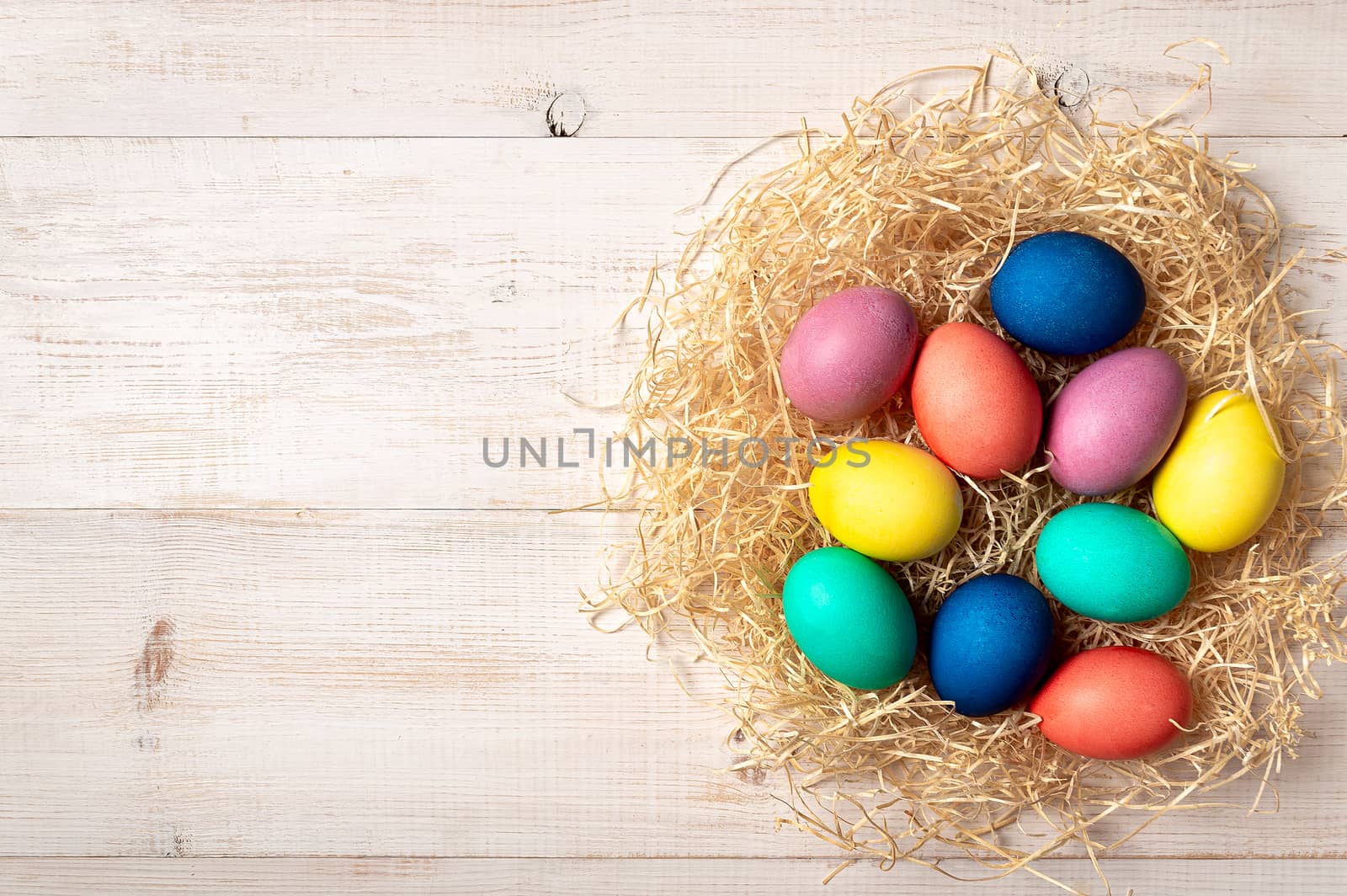 Easter concept. Colorful eggs on white wooden background with copy space for text or design. Top down view or flat lay