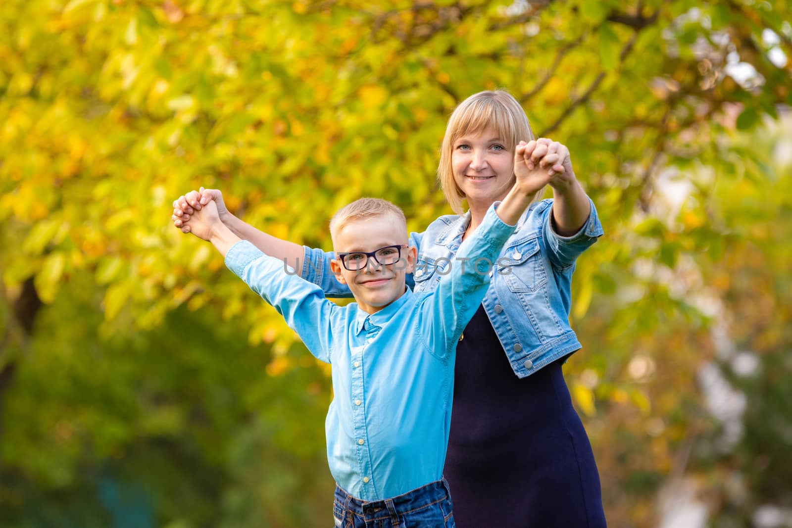 Mom and son seven-year-old son having fun in autumn park