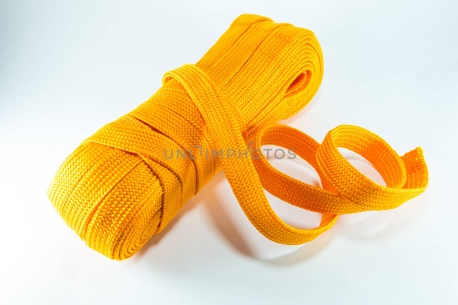 Orange rope rolls flat on white background.