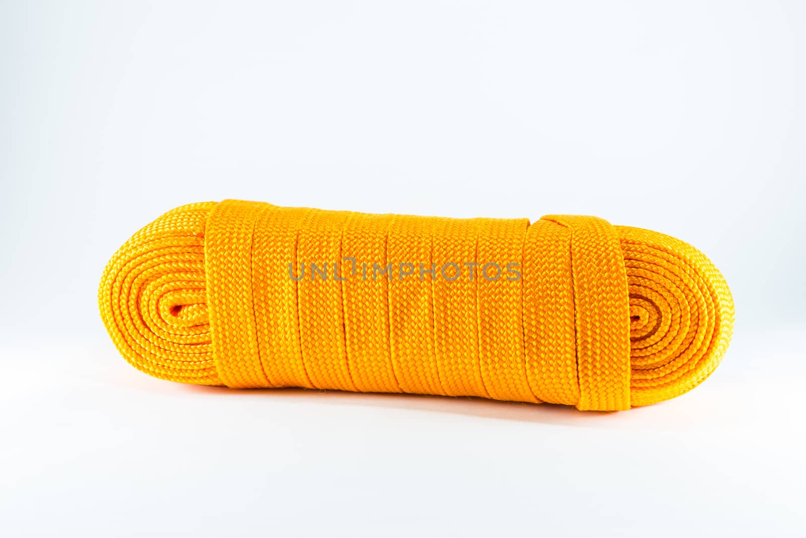 Orange rope rolls flat on white background.
