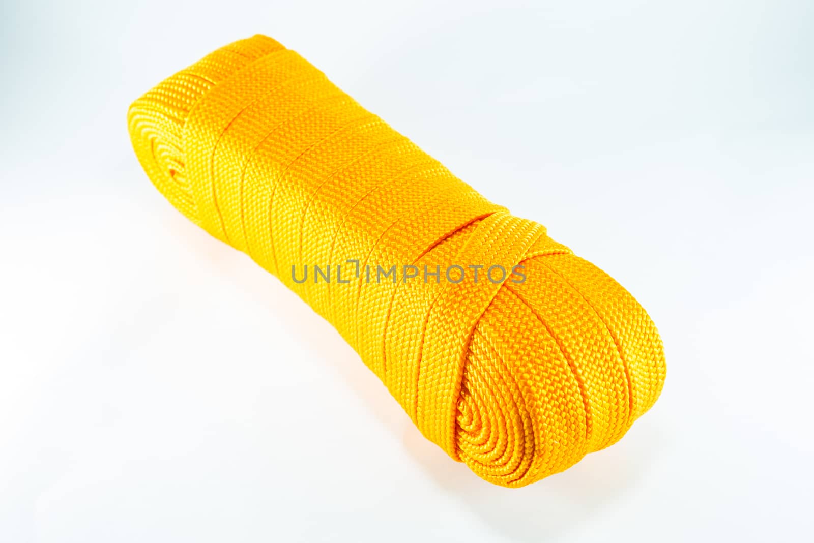 Orange rope rolls flat on white background.