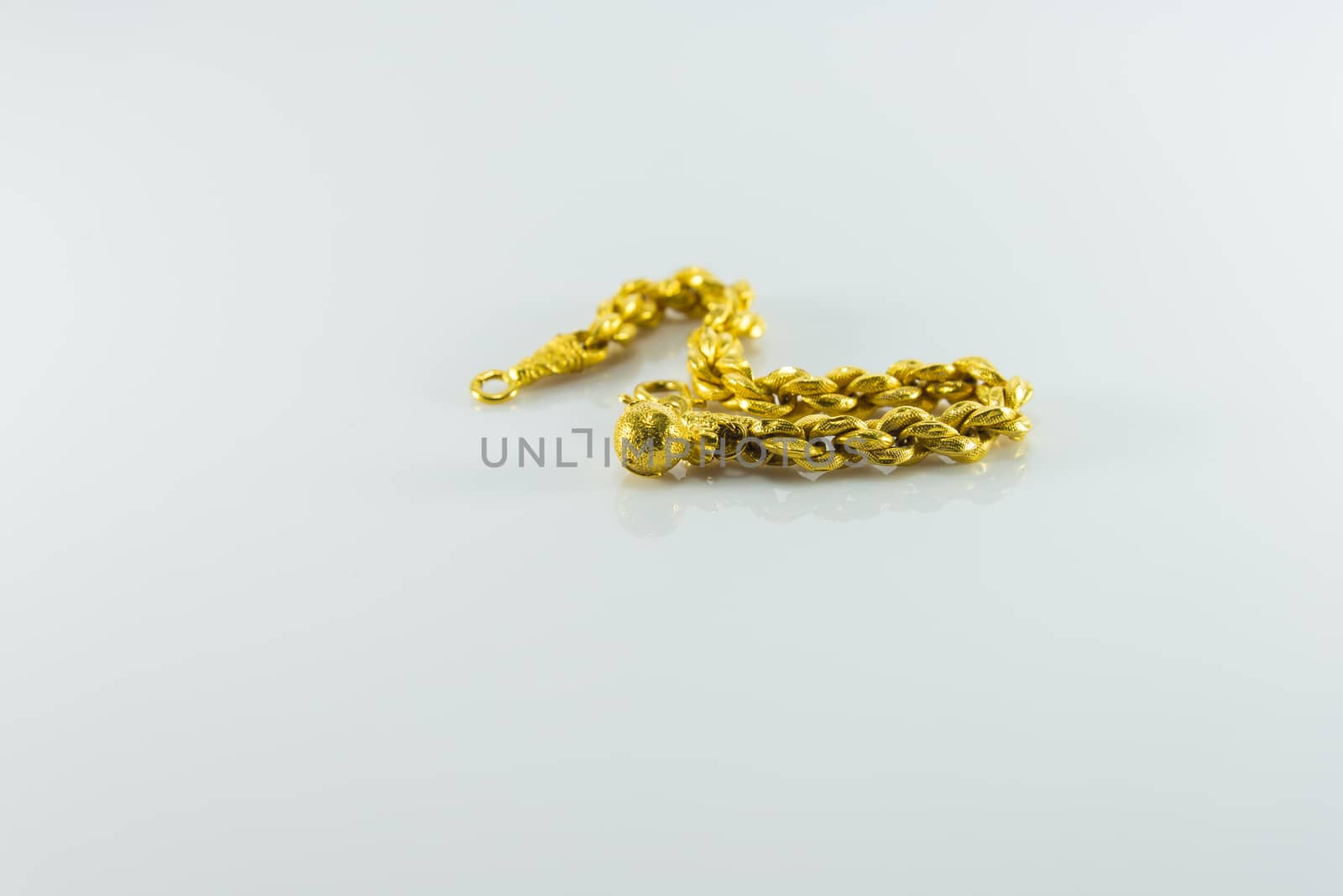 Gold bracelet on white background.