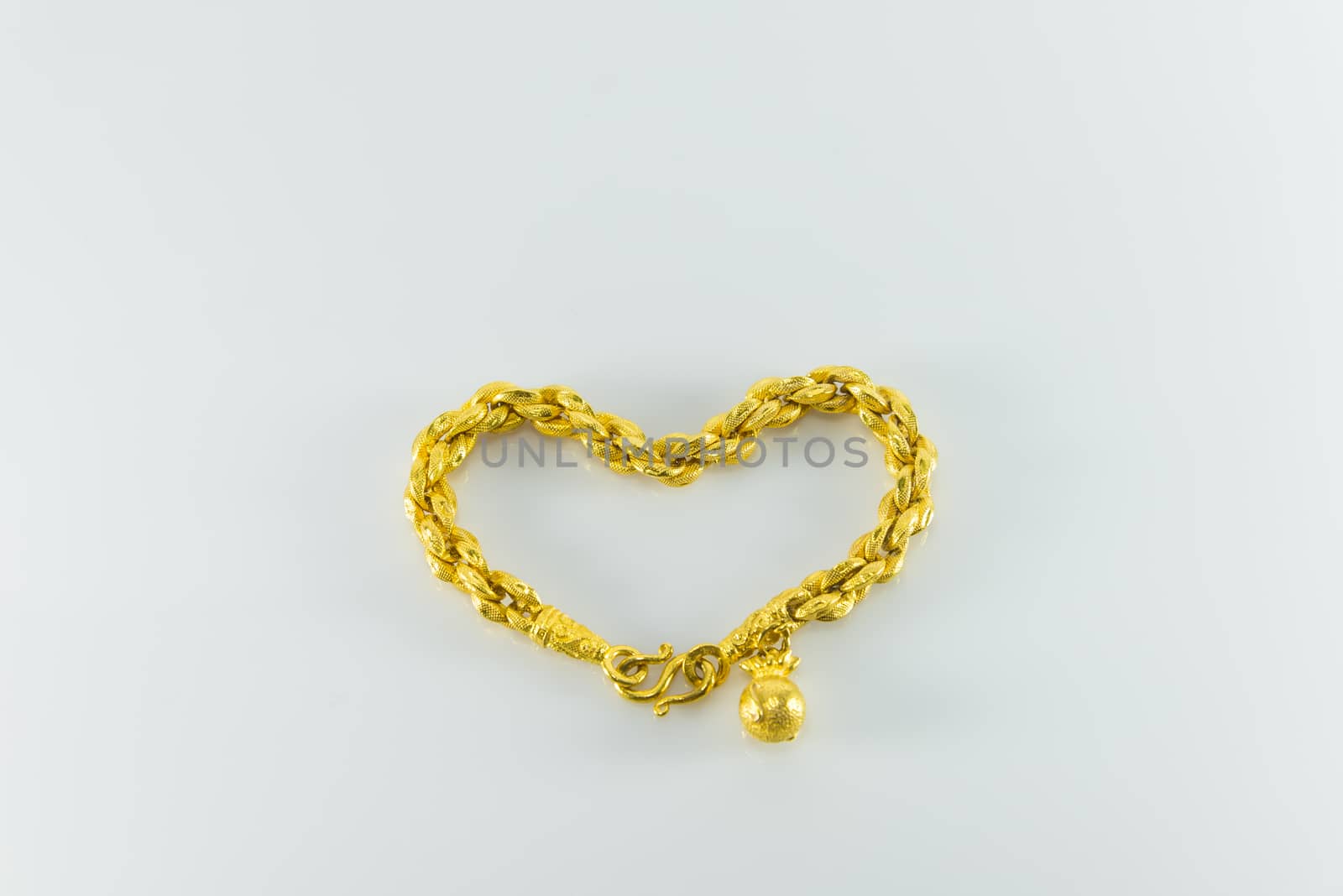 Gold bracelet on white background. heart shape.