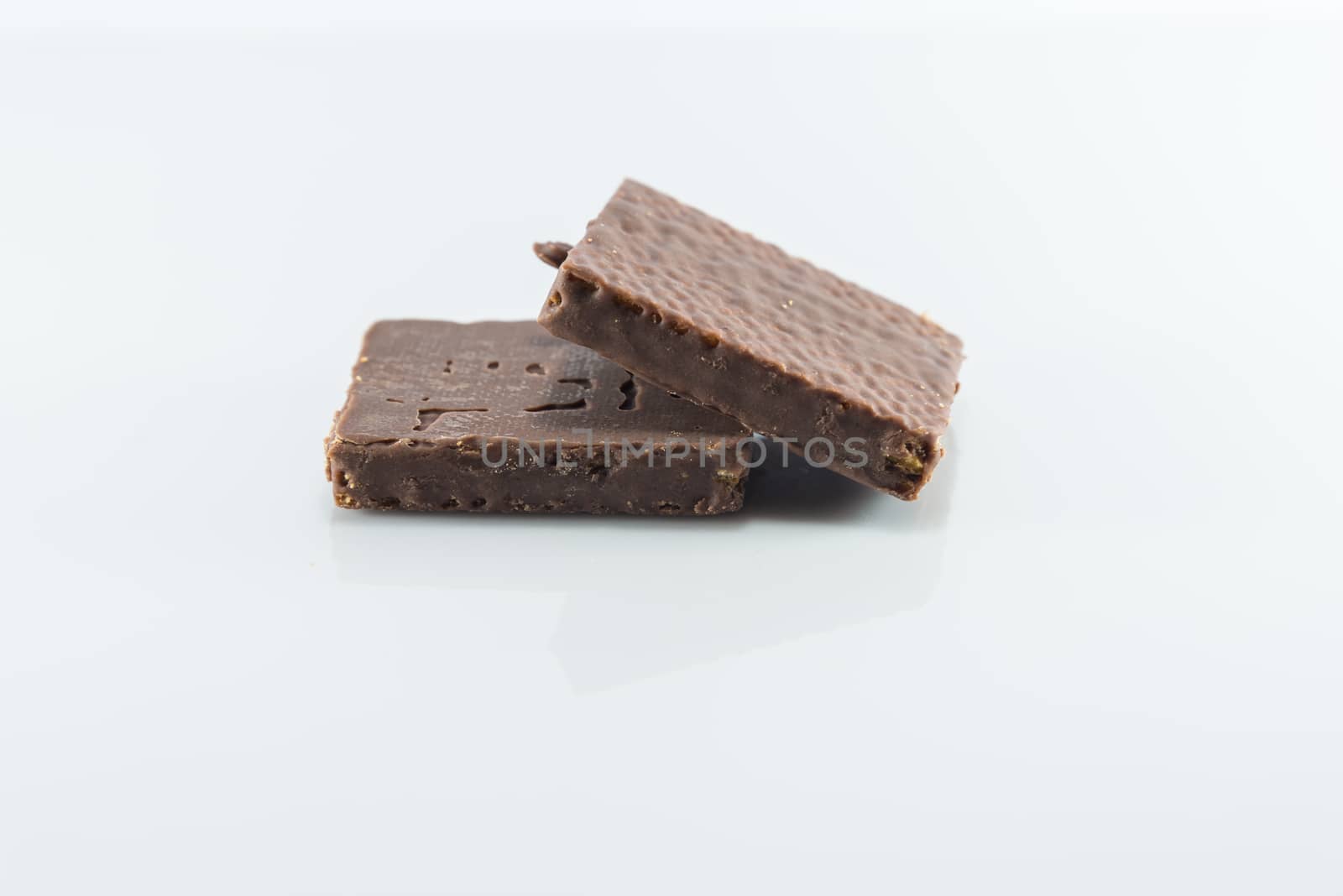 Snacks coated chocolate wafers on white background.