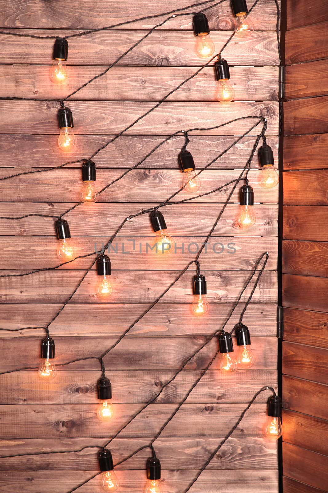 Decorative light bulbs on the background of wooden wall