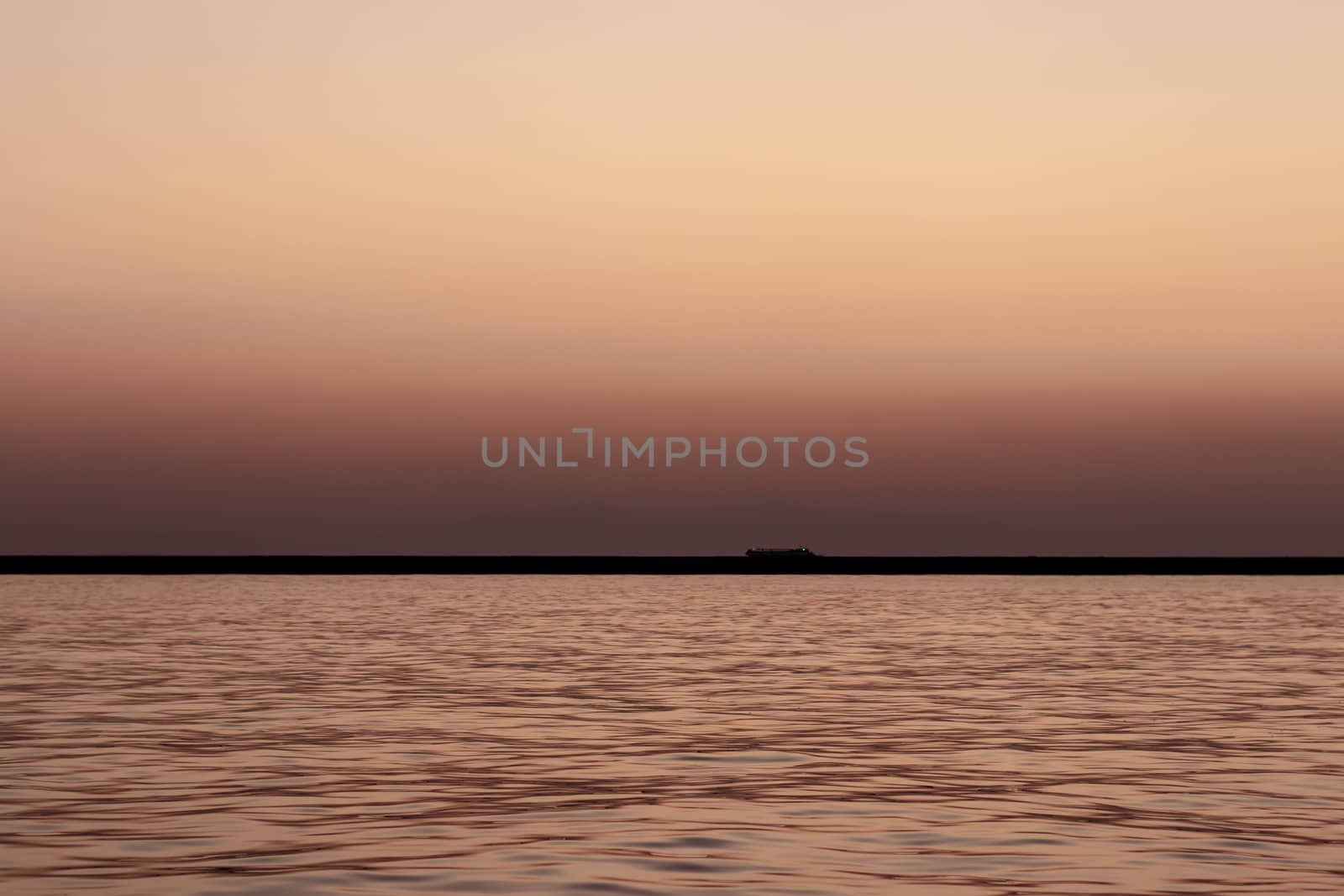 a wide seascape shoot with very well composed colors and black horizon from izmir bay - orange color dominated. photo has taken at izmir/turkey.