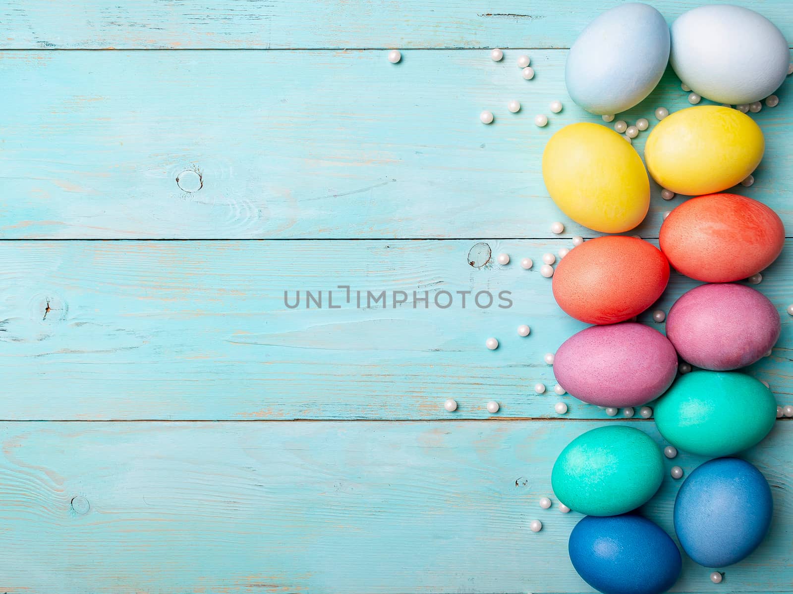 Easter concept. Colorful eggs on blue wooden background with copy space for text. Top down view or flat lay