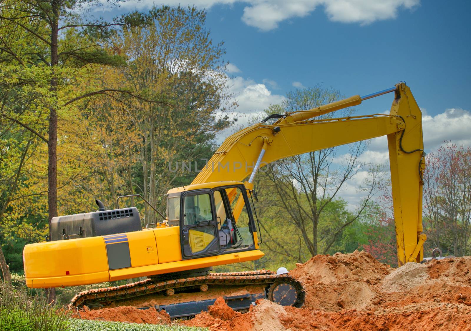 A front end loader atop a pile of dirt