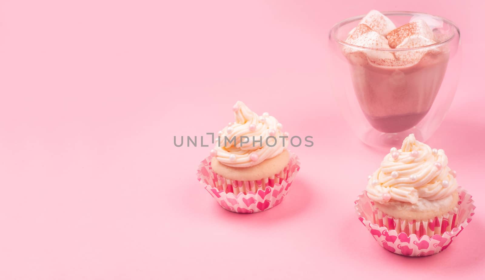 Valentine day love cupcake decorated with cream and hot chocolate on pink background with copy space for text