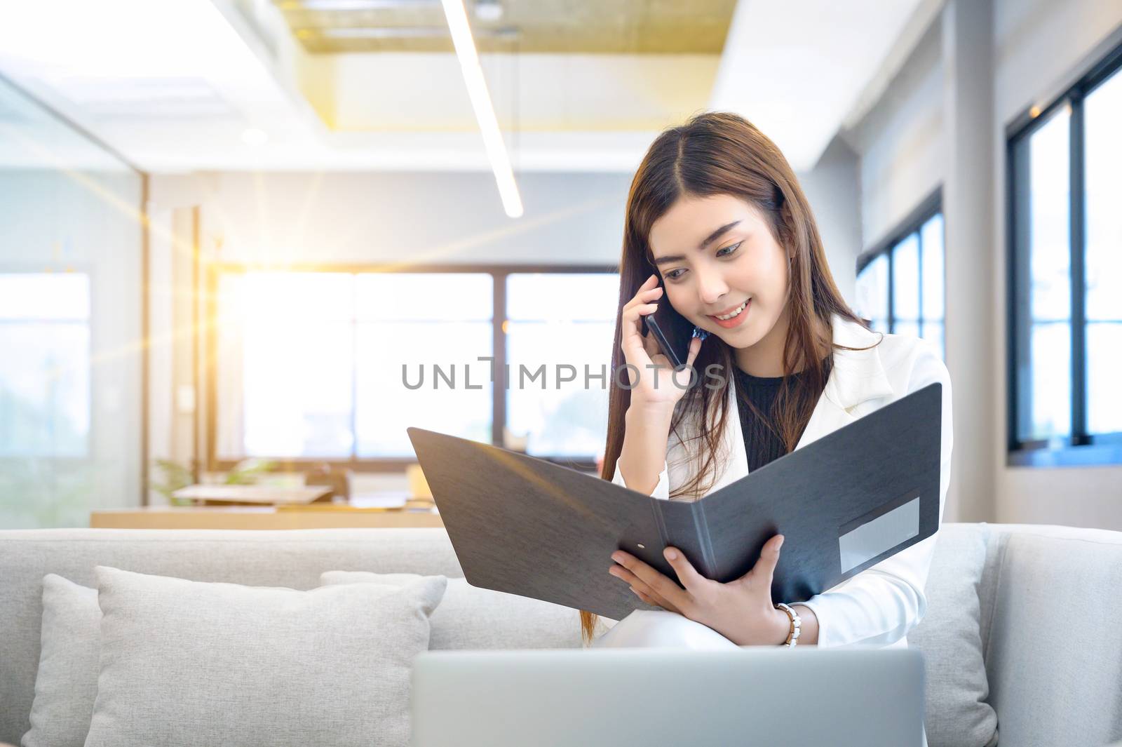 Business women holding files and talking on the phone