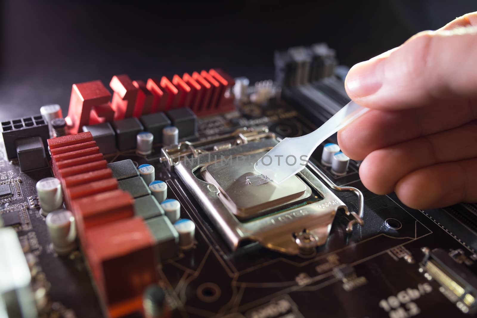 Application of thermal paste on the laptop processor chip for high-quality cooling. Spreading thermal compound to iprove cooling performance. Upgrade or PC repair concept. by petrsvoboda91