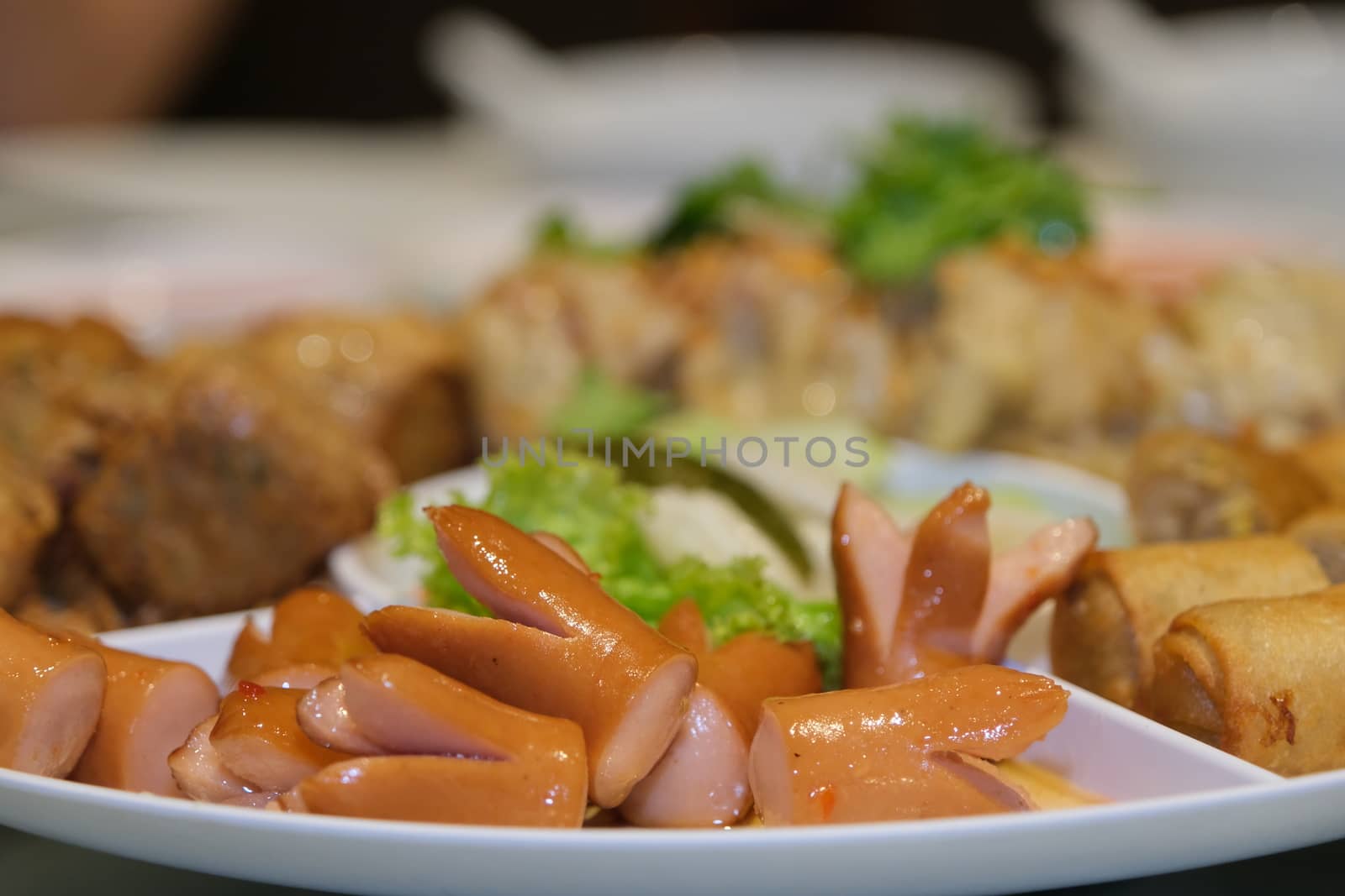 The Sliced on a plate in the form of ham sausage and vegetables in a restaurant, appetizer.