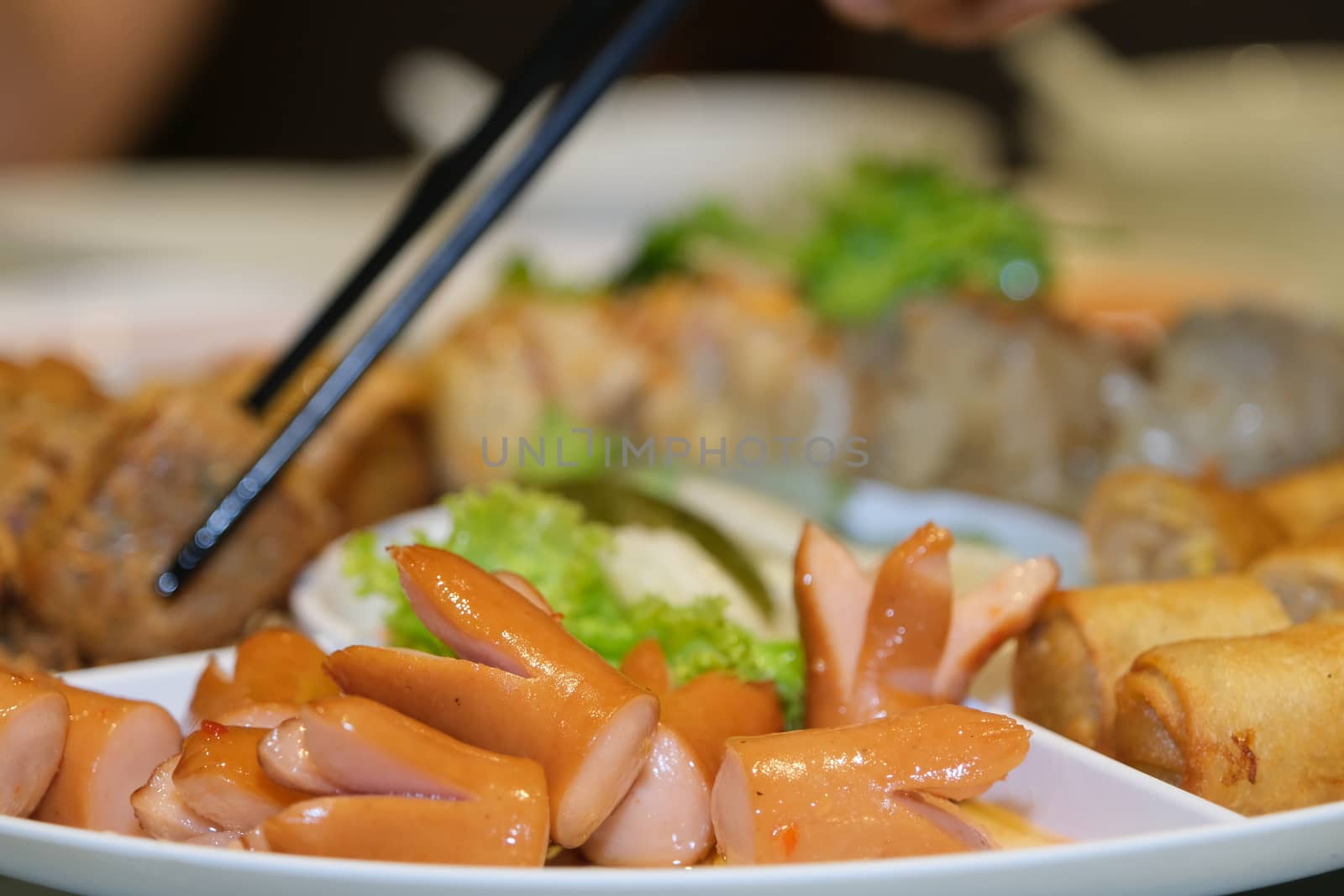 Sliced on a plate in the form of ham sausage and vegetables in a restaurant, appetizer, Selected focus by peerapixs