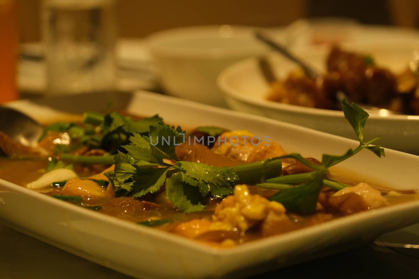 Beef stew with potatoes, carrots and herbs on black background with copy space, side view by peerapixs