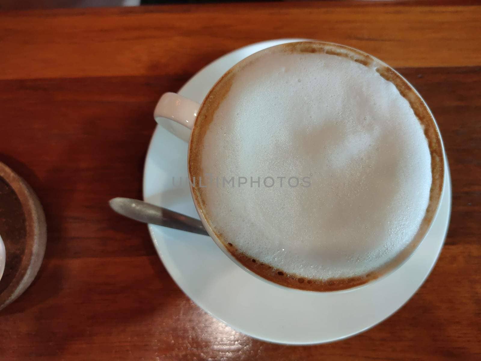 Cappuccino or latte with frothy foam, blue coffee cup top view closeup isolated on white background. Cafe and bar, barista art concept. by peerapixs