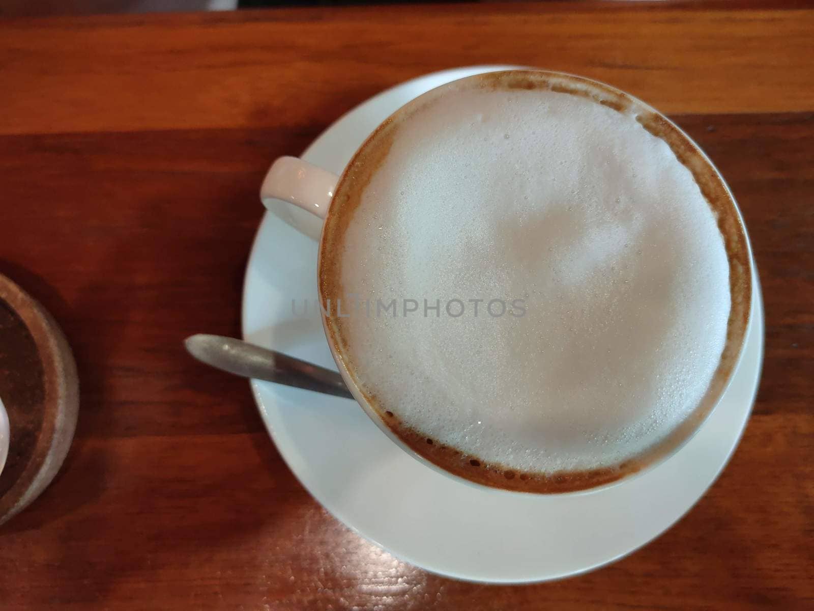 The Cappuccino or latte with frothy foam, blue coffee cup top view closeup isolated on white background. Cafe and bar, barista art concept.