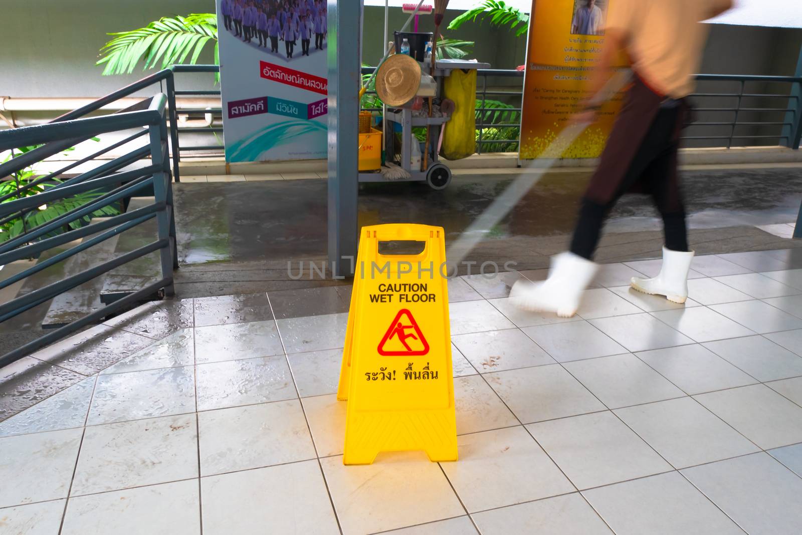 Janitor Mopping With Wet Floor Sign In walk way