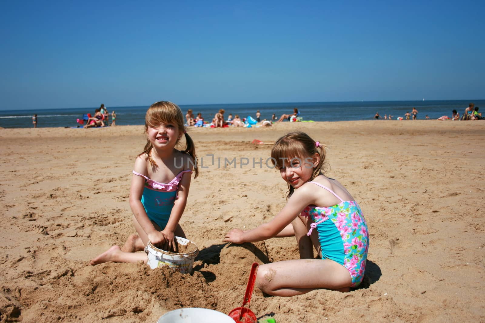 two blonde sisters on the beach