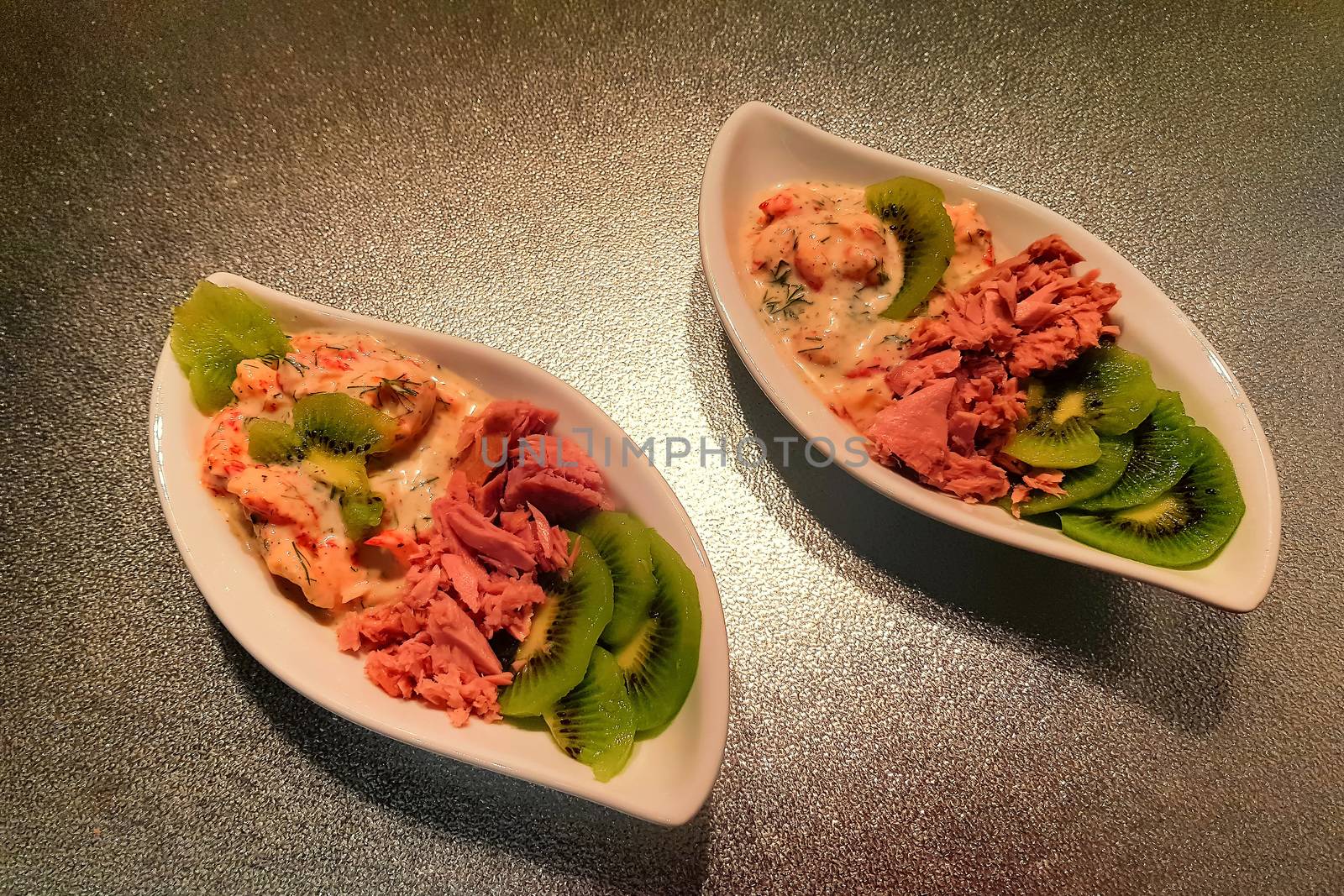 Healthy diet food small bowl lunch with tomatoes, tuna, kiwi, shrimp homemade sugarless sauce.