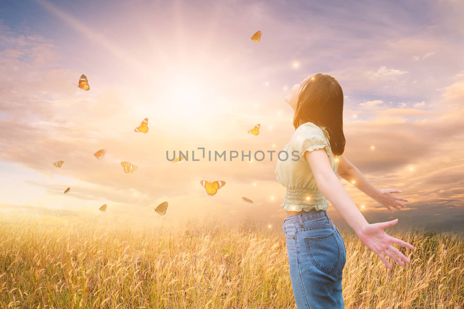 Freedom And Healthy a girl stretching her arms in the sun among the butterflies by sarayut_thaneerat