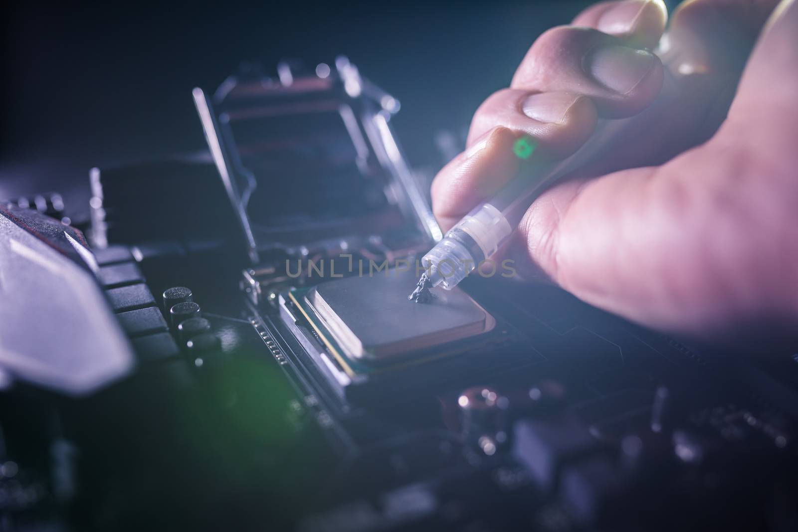 Close up to technician squeezing or application the thermal paste compound on the top of main cpu in the socket. Concept of repairing or upgrading computer hardware. by petrsvoboda91