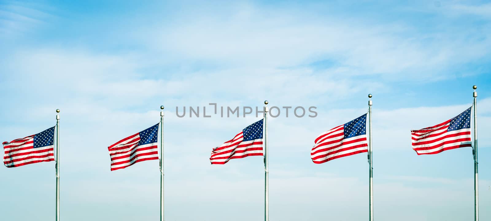 Group of five American flags waving in the wind. Patriotic concept