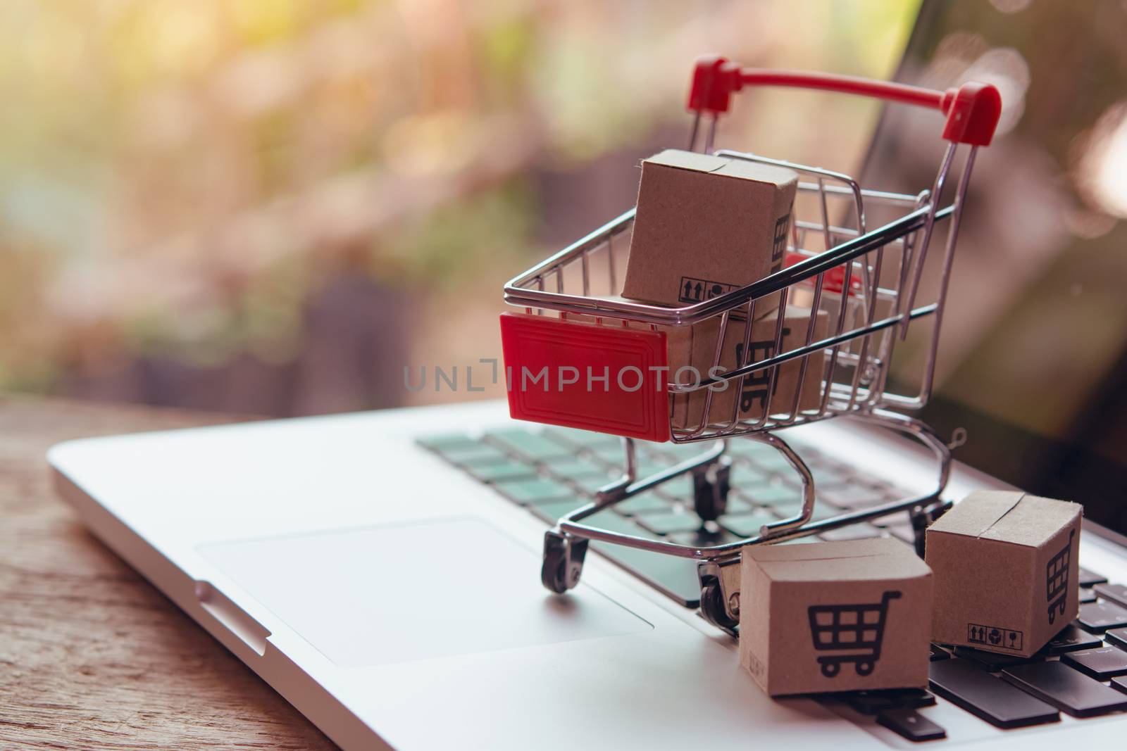 Shopping online concept - Parcel or Paper cartons with a shopping cart logo in a trolley on a laptop keyboard. Shopping service on The online web. offers home delivery.

