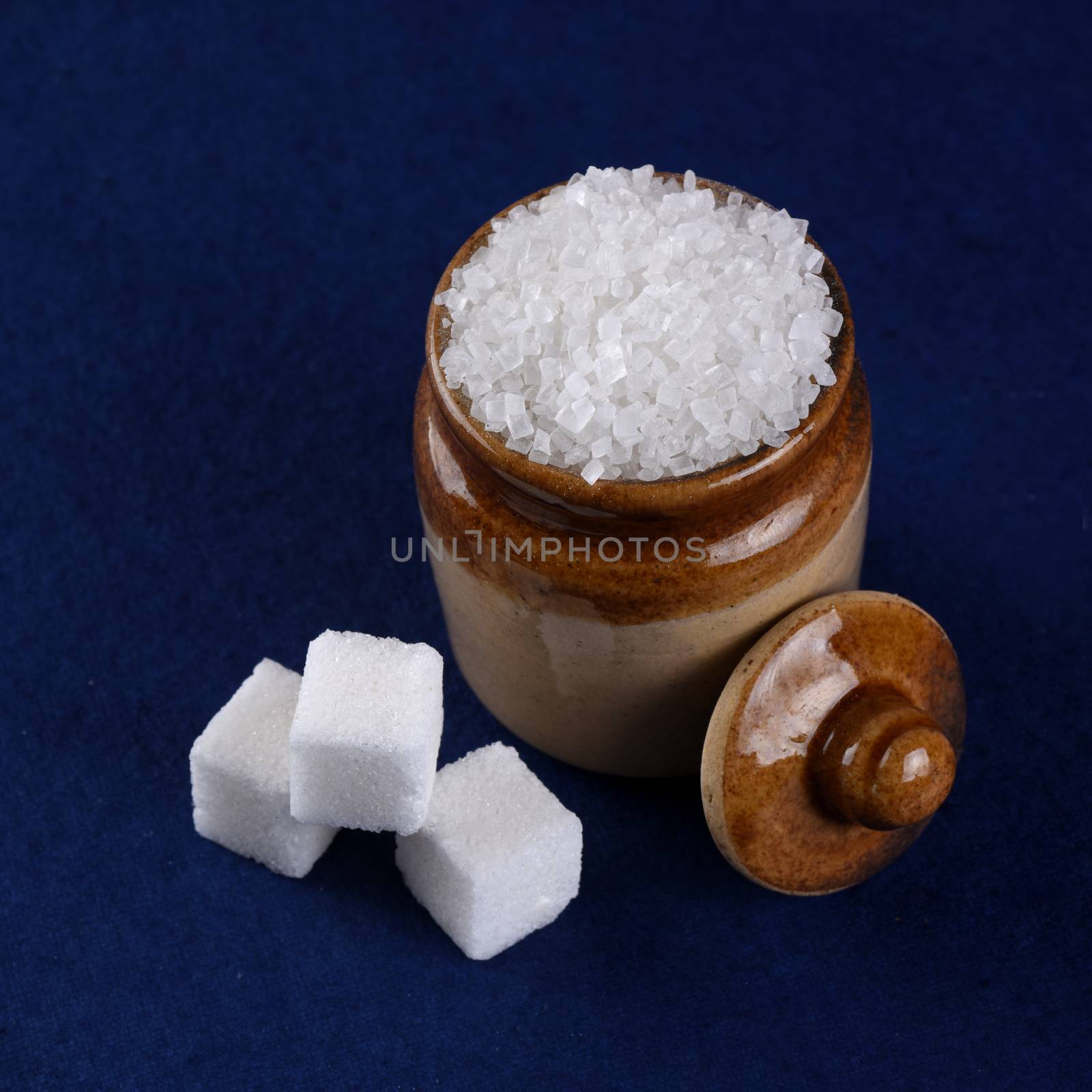 Sugar. white granulated sugar and refined sugar on a blue background