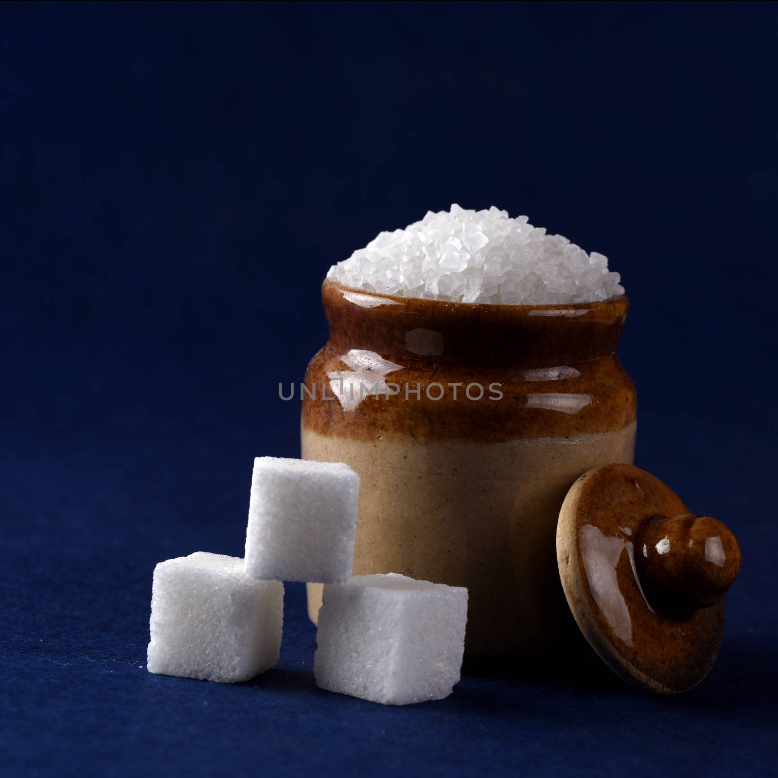 Sugar. white granulated sugar and refined sugar on a blue background