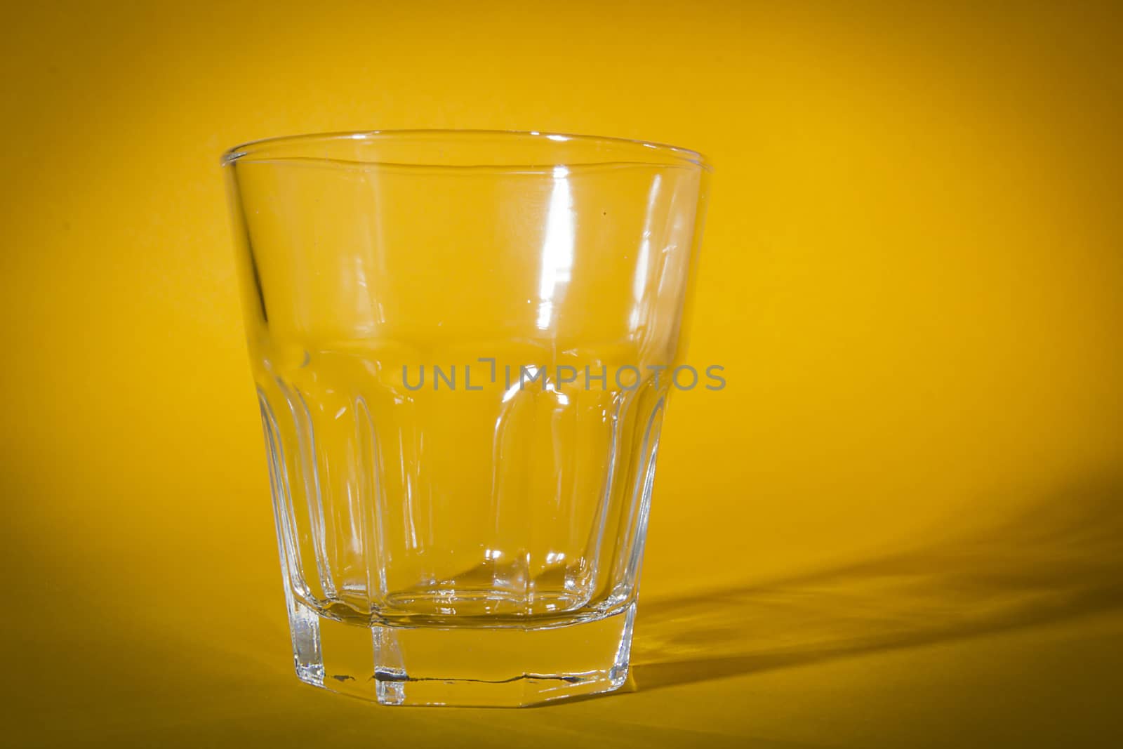 Empty glass wine-glass on a yellow background