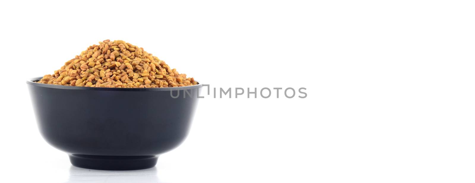 Fenugreek seeds in bowl isolated on white background