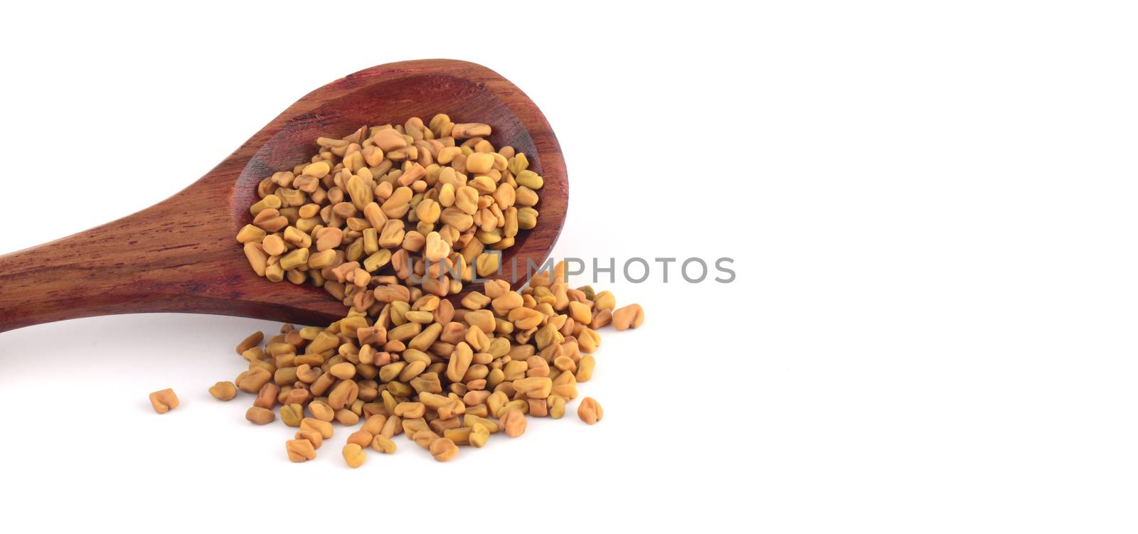 Fenugreek seeds in wooden spoon isolated on white background