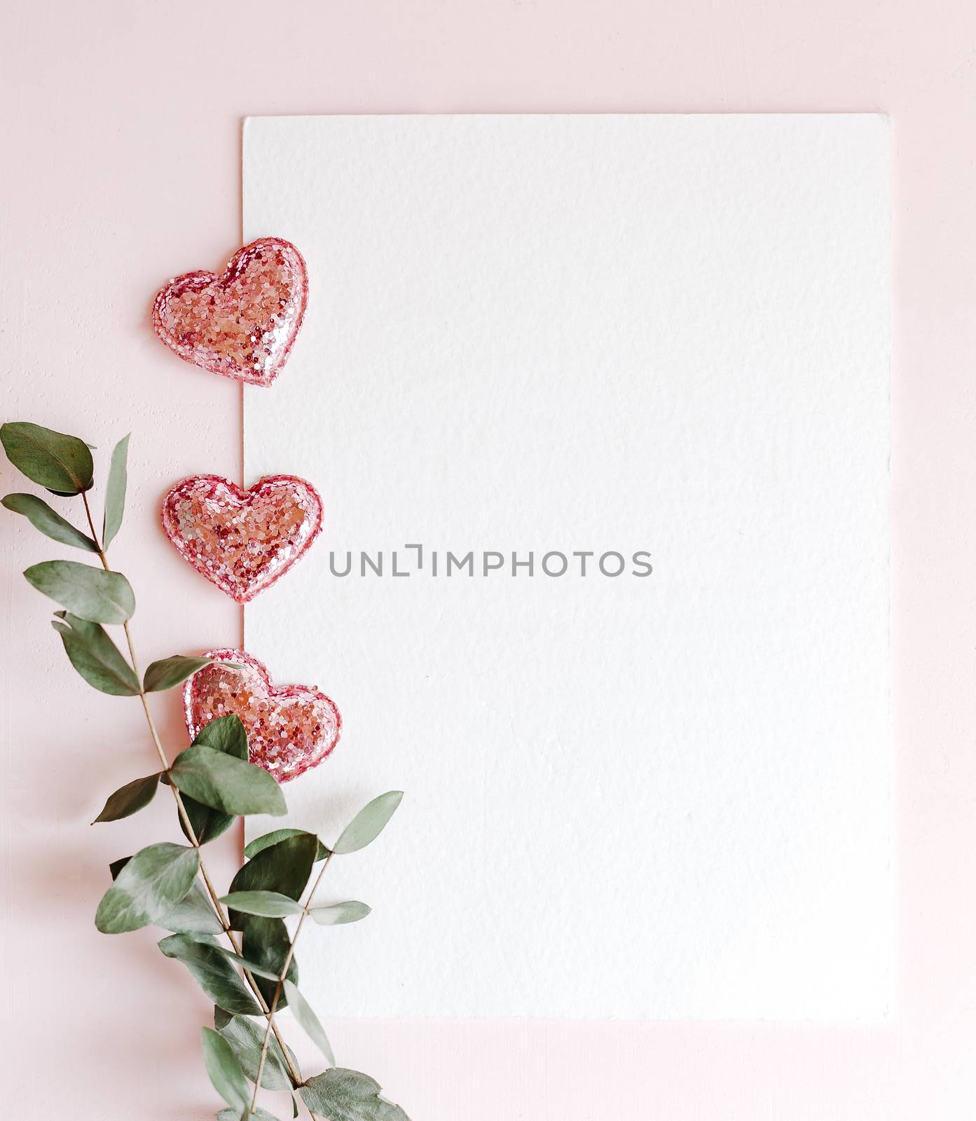 Background with copy space blank on pink background with pink glittered hearts, eucalyptus branch. White paper top view, flat lay, minimal style. Moke up card