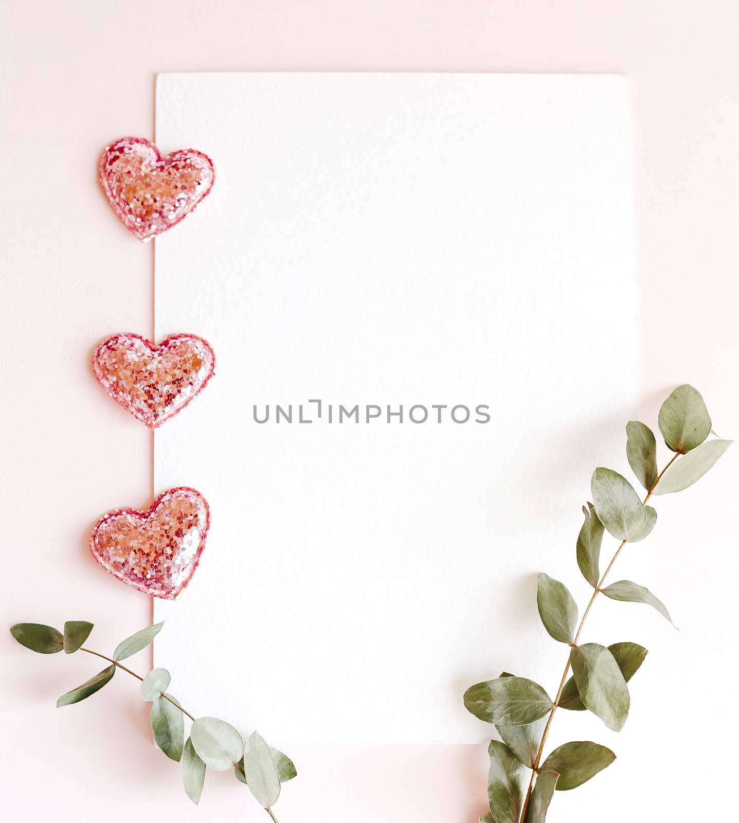 Background with copy space blank on pink background with pink glittered hearts, eucalyptus branch. White paper top view, flat lay, minimal style. Moke up card