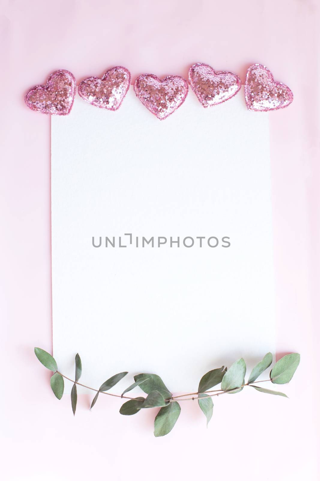 Background with copy space blank on pink background with pink glittered hearts, eucalyptus branch. White paper top view, flat lay, minimal style. Moke up card. by Denys_N