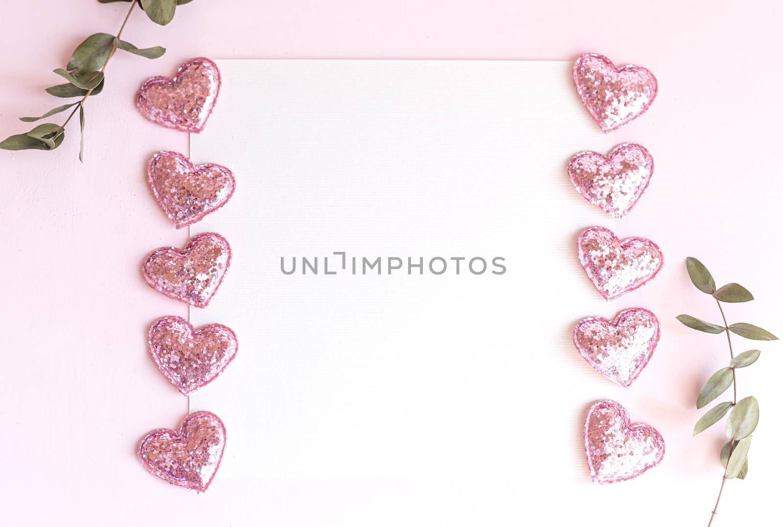 Background with copy space blank on pink background with pink glittered hearts, eucalyptus branch. White paper top view, flat lay, minimal style. Moke up card