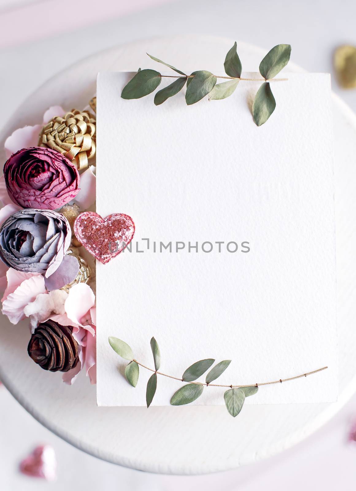 Background with copy space blank on white table with glitter heart, eucalyptus branch, flowers and leafs. White paper top view, flat lay, minimal style. Moke up card. by Denys_N