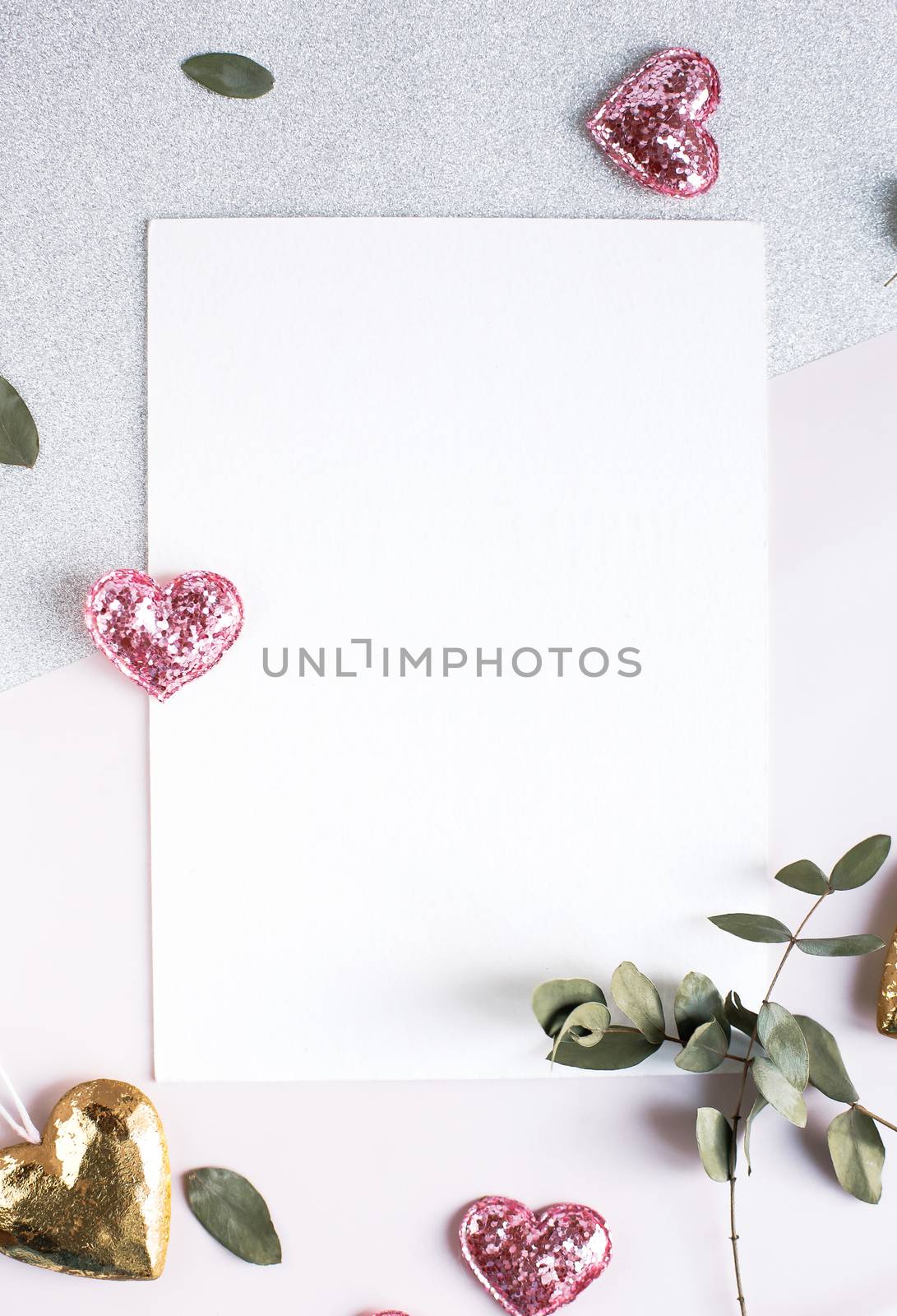 Background with copy space blank on white table with glitter heart, eucalyptus branch, flowers and leafs. White paper top view, flat lay, minimal style. Moke up card. by Denys_N