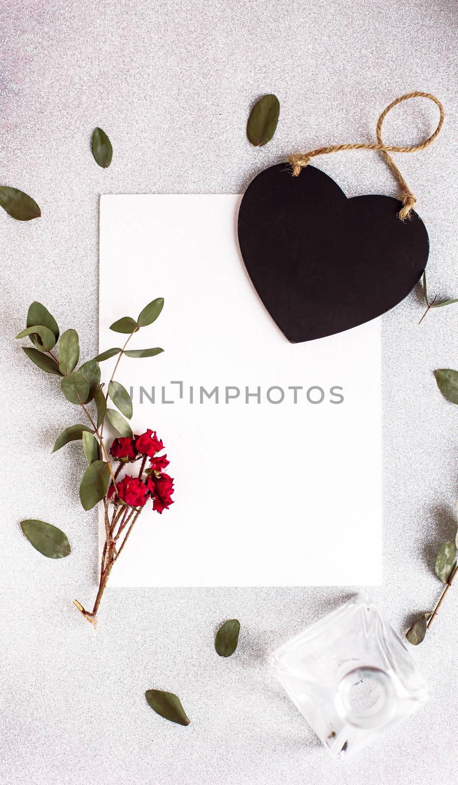 Background with copy space blank on table with black heart, eucalyptus branch, roses flowers and leafs. White paper top view, flat lay, minimal style. Moke up card. by Denys_N
