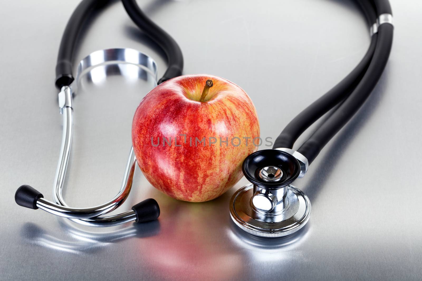 Fresh red apple and stethoscope on stainless steel  by tab1962