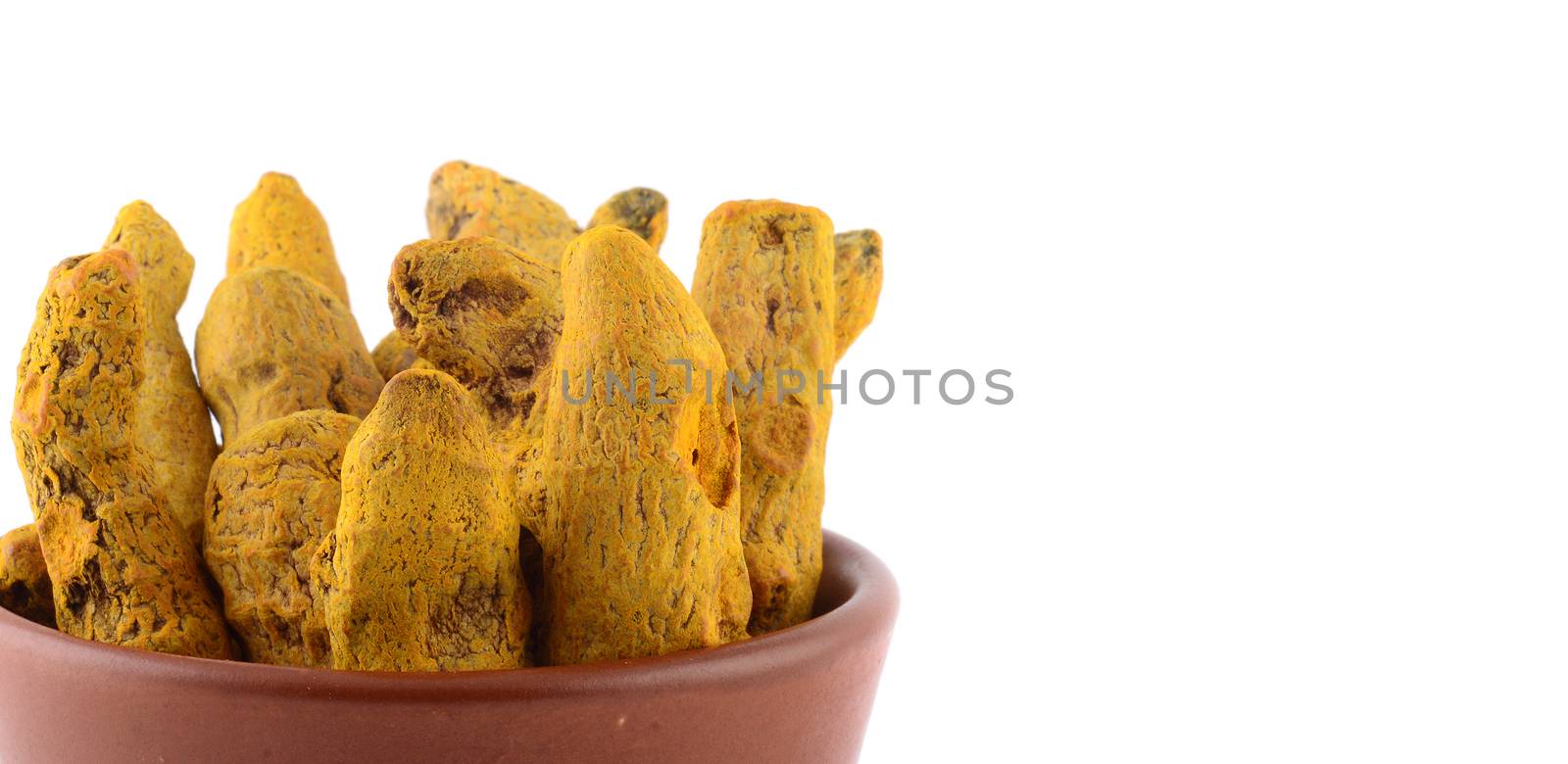 Dry Turmeric roots or barks in clay pot isolated on white background