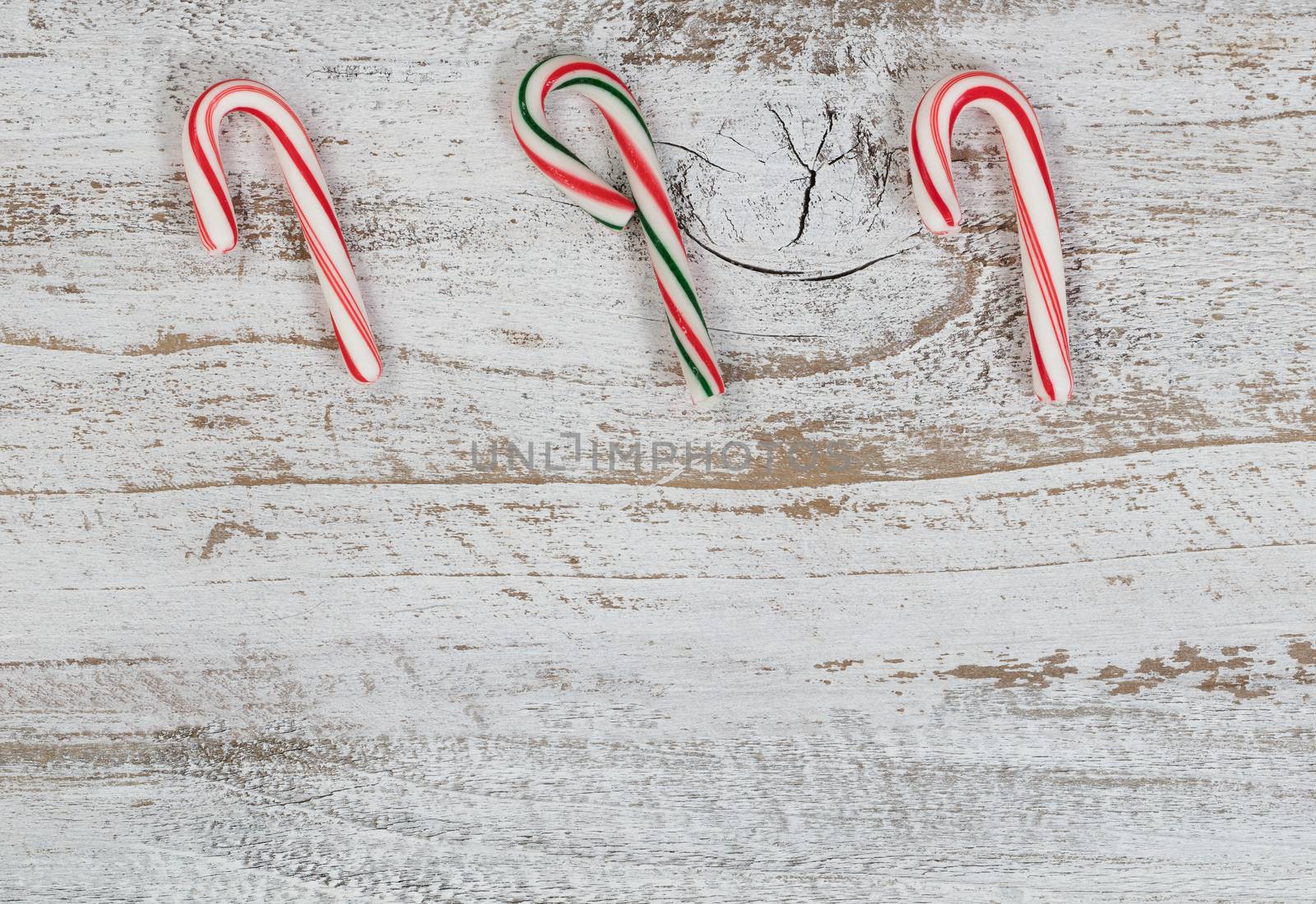 Small candy canes on rustic wood for Christmas concept 