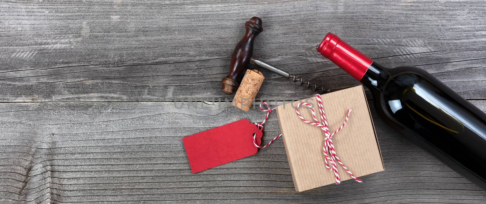 Fathers day gift box with red wine bottle and corkscrew on vintage wooden plank background