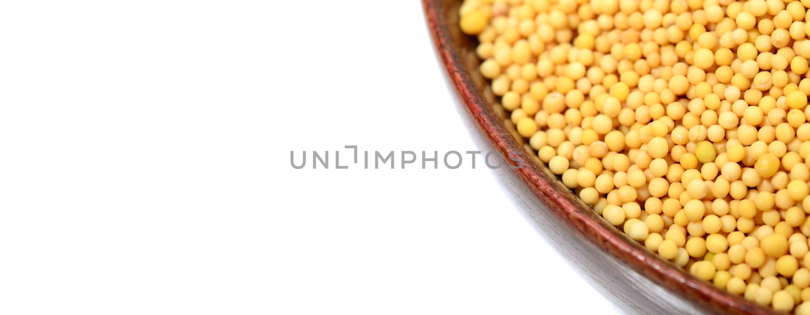 yellow mustard seeds in bowl isolated on white background