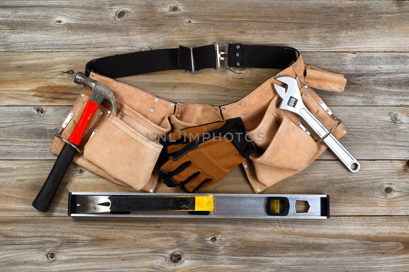 Leather tool belt with tools on rustic wooden boards  by tab1962