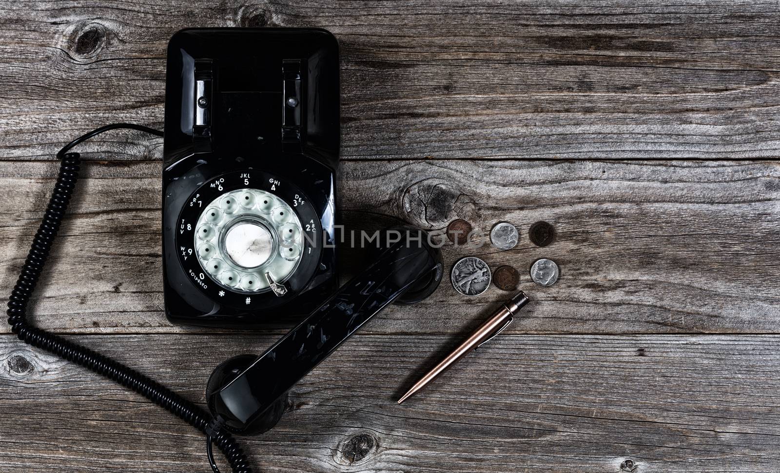 Old telephone with various old vintage objects on stressed wood by tab1962