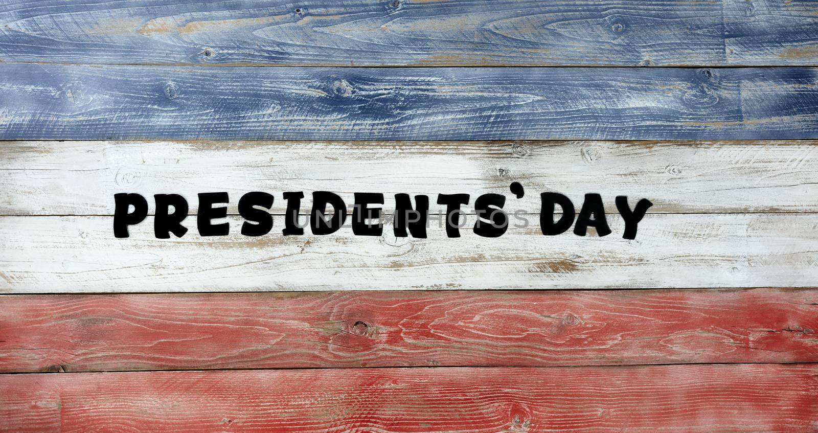Presidents day in large text letters on rustic painted wooden boards with USA traditional colors 