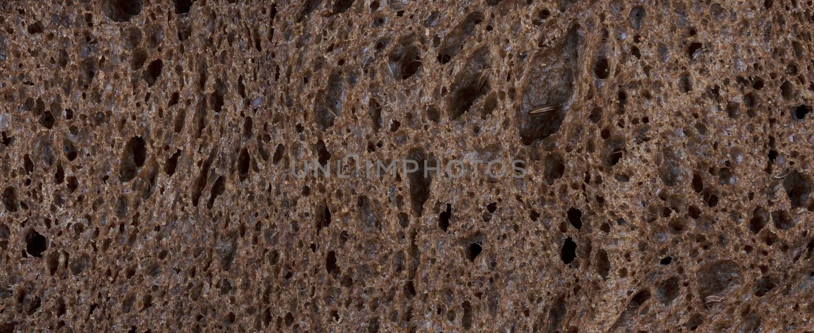 Dark healthy organic bread in filled frame format background by tab1962